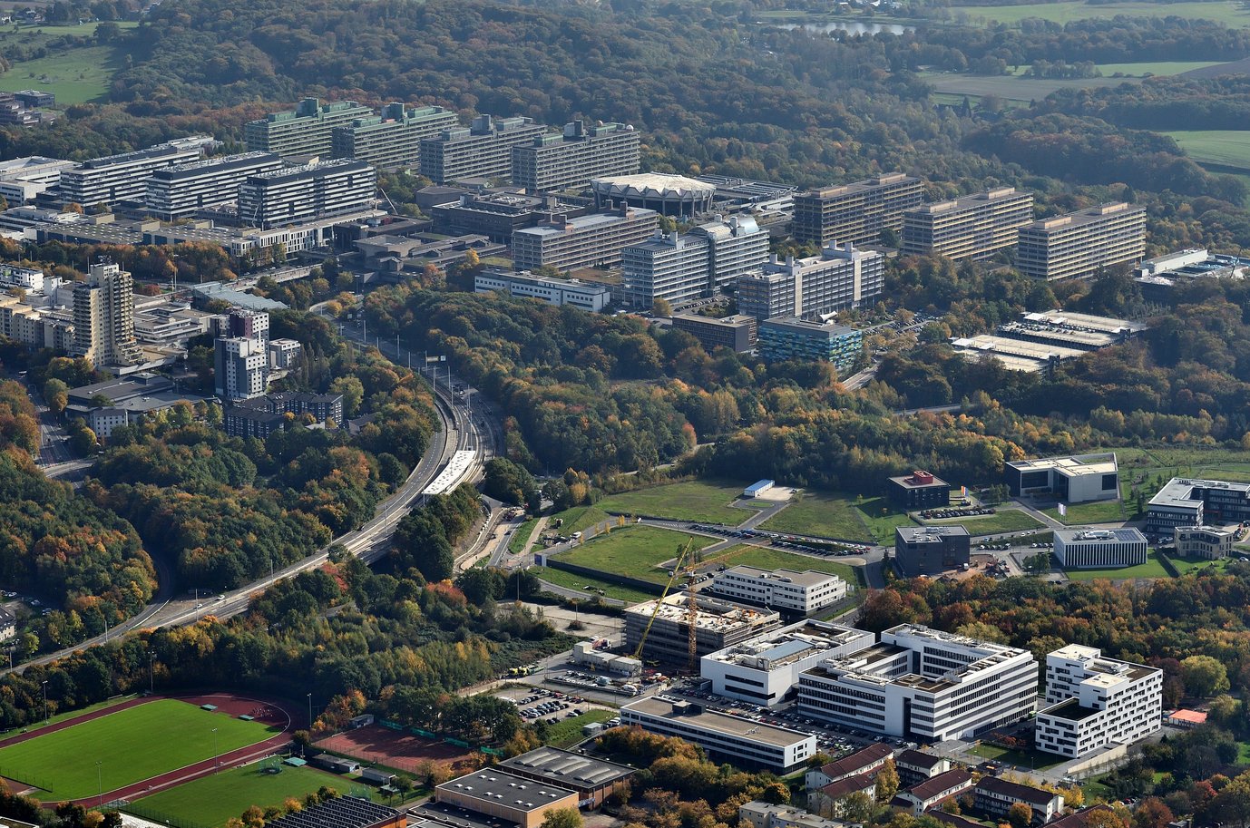 Aerial view of various buildings showing the Ruhr University Bochum in the background and the University of Health in the foreground.