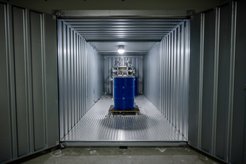 Um zu testen, wie robust und wie reproduzierbar der Funkfingerabdruck ist, haben die Forschenden ihre Technik in einem Container aufgebaut. Bewegungen des blauen Fasses lassen sich mit der Funkwellenüberwachung detektieren.